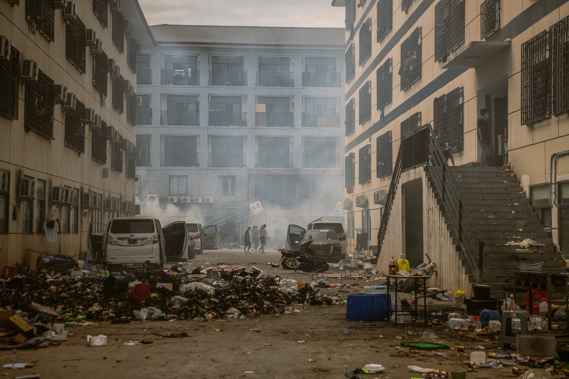 Smoke billows inside the Shunda Park complex in Min Let Pan, Myanmar, as workers who refused to leave burn office furniture and documents for fuel. Approximately 900 Chinese workers remained in the ruins for weeks, fearing that returning home would lead to criminal prosecution by Chinese authorities.