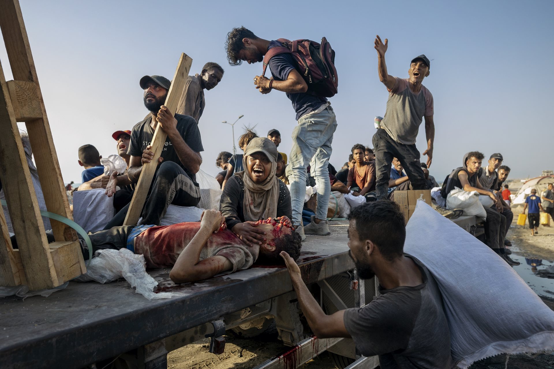 A woman screams for her son who was shot while trying to collect aid from a truck near the Zikim crossing, in the north of Gaza along the coast, and is being rushed to hospital on the same truck. Gaza City, Gaza Strip.